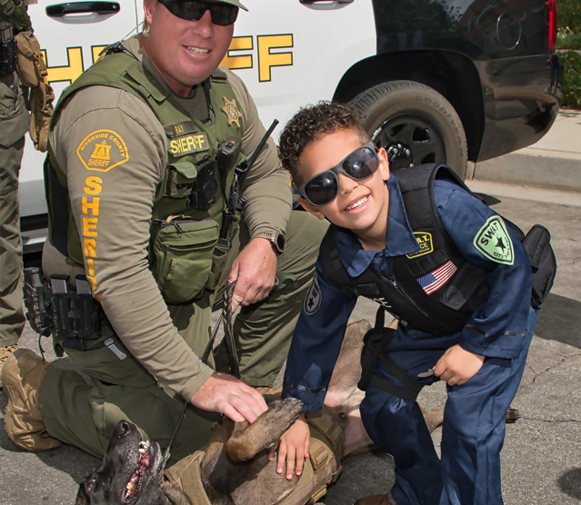 Boy petting a K-9 unit dog at the Public Safety Expo